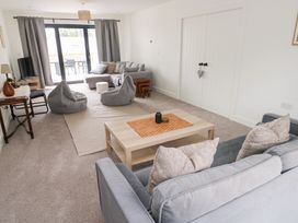 A living room with a sofa, bean bags, and a coffee table at Ty Landsker in Houghton near Neyland