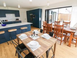 A kitchen with an island and dining area at Ty Landsker in Houghton near Neyland