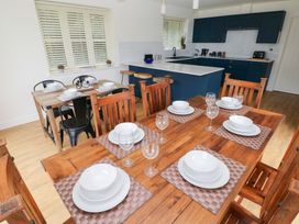 A dining room with a table set for meals at Ty Landsker in Houghton near Neyland
