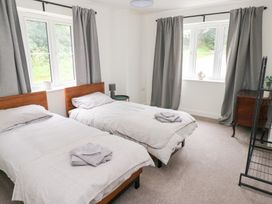 A bedroom with two single beds and a window at Ty Landsker in Houghton near Neyland