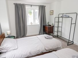 A bedroom with two beds and a window at Ty Landsker in Houghton near Neyland
