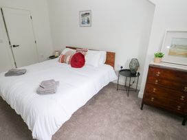 A bedroom with a bed and nightstand at Ty Landsker in Houghton near Neyland
