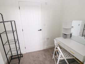 A bedroom with a desk and mirror at Ty Landsker Houghton near Neyland