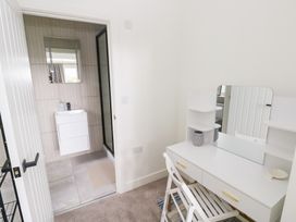 A bathroom with a vanity table and door at Ty Landsker in Houghton near Neyland
