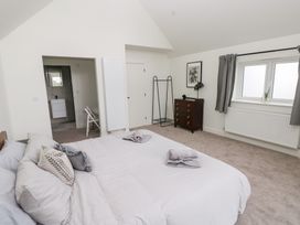 A bedroom with a bed and dresser at Ty Landsker Houghton near Neyland