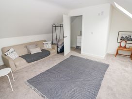 A bedroom with a sofa and mirror at Ty Landsker Houghton near Neyland