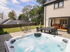 An outdoor area featuring a hot tub and dining set at Ty Landsker in Houghton near Neyland