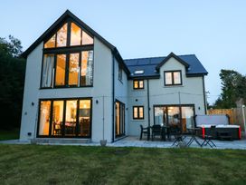 An outdoor view of a house with a patio and garden at Ty Landsker in Houghton near Neyland