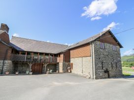 An exterior view of a house with a balcony at Stud Farm House in Bleddfa near Knighton
