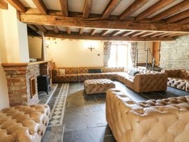 A living room with a brick fireplace and sofa at Stud Farm House in Bleddfa near Knighton