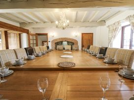 A dining room with a large wooden table and chairs at Stud Farm House Bleddfa near Knighton