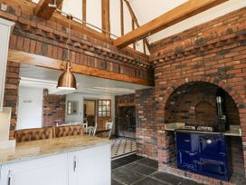 A kitchen featuring a brick wall and a cooking range at Stud Farm House Bleddfa near Knighton