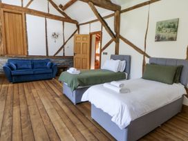 A bedroom with two beds and a sofa at Stud Farm House in Bleddfa near Knighton