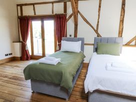 A bedroom with two beds and wooden flooring at Stud Farm House in Bleddfa near Knighton