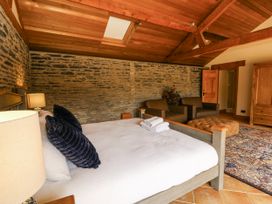 A bedroom with a bed and chairs at Stud Farm House in Bleddfa near Knighton