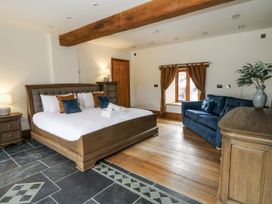 A bedroom with a bed, sofa, and window at Stud Farm House in Bleddfa near Knighton