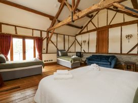 A bedroom with multiple beds and a blue sofa at Stud Farm House Bleddfa near Knighton