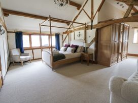 A bedroom with a four-poster bed and an armchair at Stud Farm House Bleddfa near Knighton