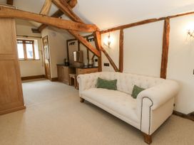 A living room with a sofa and wooden beams at Stud Farm House Bleddfa near Knighton
