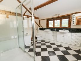 A bathroom with a shower, bathtub, sinks and windows at Stud Farm House in Bleddfa near Knighton