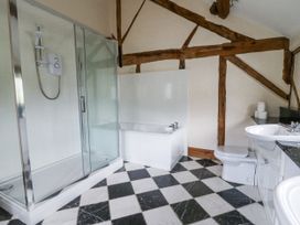 A bathroom with a shower, bathtub, toilet, and sink at Stud Farm House in Bleddfa near Knighton