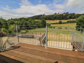 An outdoor space with a deck and railing overlooking a landscape at Stud Farm House Bleddfa near Knighton