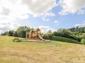 A playhouse with slide and a bench at Stud Farm House, Bleddfa near Knighton