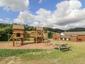 A playground with a climbing frame and picnic table at Stud Farm House Bleddfa near Knighton