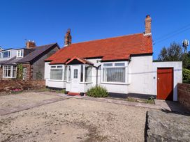 A house with a red roof and front door at Godetia Cottage in Seahouses