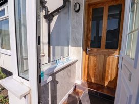 An entrance with a wooden door and welcome sign at Godetia Cottage in Seahouses