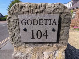 A stone house number sign reading Godetia 104 at Godetia Cottage Seahouses