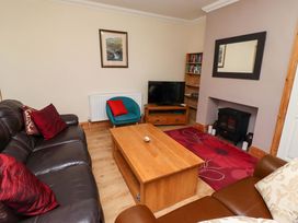 A living room with a sofa and coffee table at Godetia Cottage in Seahouses