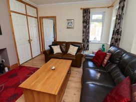 A living room with a sofa and coffee table at Godetia Cottage Seahouses