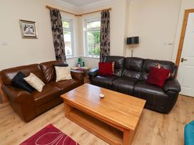 A living room with sofas and a coffee table at Godetia Cottage in Seahouses