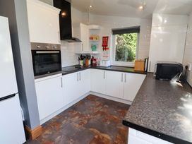 A kitchen with appliances and cabinets at Godetia Cottage in Seahouses