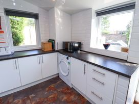 A kitchen with a microwave and washing machine at Godetia Cottage Seahouses