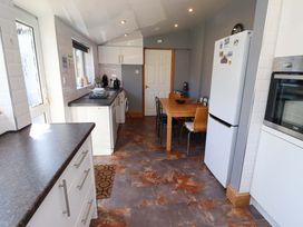 A kitchen with a table and chairs at Godetia Cottage in Seahouses