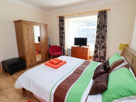 A bedroom with a double bed and wardrobe at Godetia Cottage Seahouses