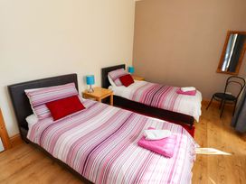 A bedroom with two single beds and a bedside table at Godetia Cottage in Seahouses