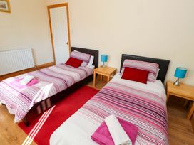 A bedroom with two single beds and a radiator at Godetia Cottage in Seahouses