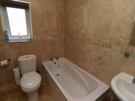 A bathroom with a bathtub and sink at Godetia Cottage in Seahouses