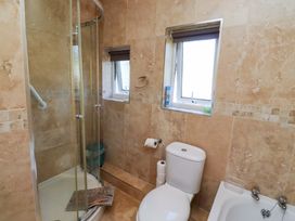A bathroom with a shower, toilet, and bathtub at Godetia Cottage in Seahouses