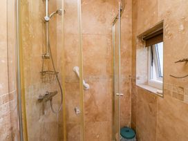 A shower area with a window and characteristics at Godetia Cottage in Seahouses