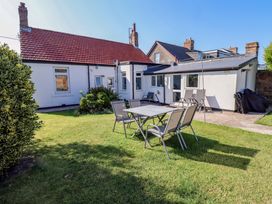 A garden with a table and chairs at Godetia Cottage Seahouses