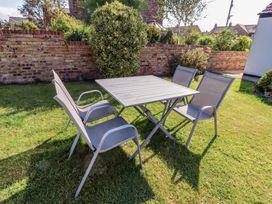 A table and chairs in a garden at Godetia Cottage Seahouses