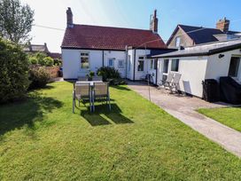 A garden with chairs and a table at Godetia Cottage in Seahouses