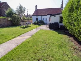 A garden with a pathway, table and chairs at Godetia Cottage in Seahouses