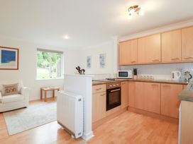 A kitchen with appliances and a sofa at Acorns in Falmouth