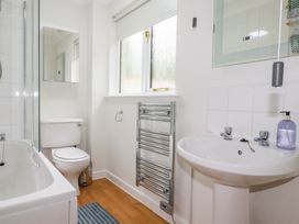 A bathroom with a bathtub, toilet, sink and towel radiator at Acorns in Falmouth
