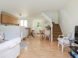 A living room with a sofa and dining area at Acorns in Falmouth
